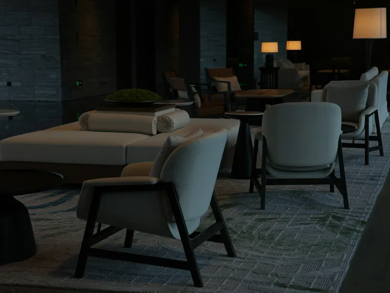 Een stille hotellounge met lage fauteuils en lampen in gedempt licht