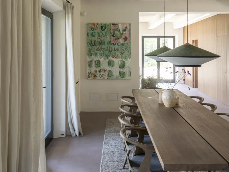 De eetkamer van een Rouchelli-villa met een lange houten tafel